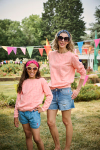 A girl and a woman wearing colourful Scamp & Dude headbands with matching sweatshirts