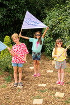 Three children holding Scamp & Dude flags and wearing Scamp & Dude outfits 