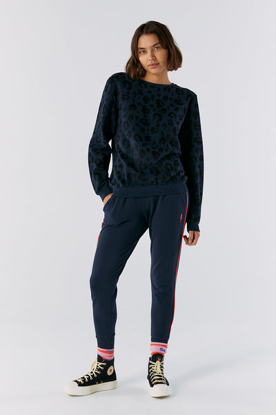 Scamp and Dude Navy Leopard Sweatshirt | Model wearing navy leopard print sweatshirt with navy leggings and black trainers