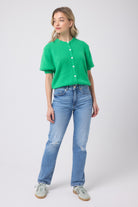 Scamp and Dude Green Short Sleeve Cardigan | Model wearing a green short sleeve cardigan with a pair of blue distressed jeans and trainers.