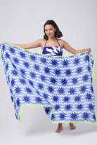 Scamp and Dude Blue with Cream Wiggle Sunstar Charity Super Scarf | Model holding a blue and white stripe super scarf with sun print detail. Worn with a matching swimsuit.