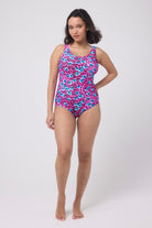 Scamp and Dude Bright Pink Paradise Cheetah Scallop Edge Swimsuit | Model wearing a pink swimsuit featuring a paradise cheetah print and scallop edge detail.