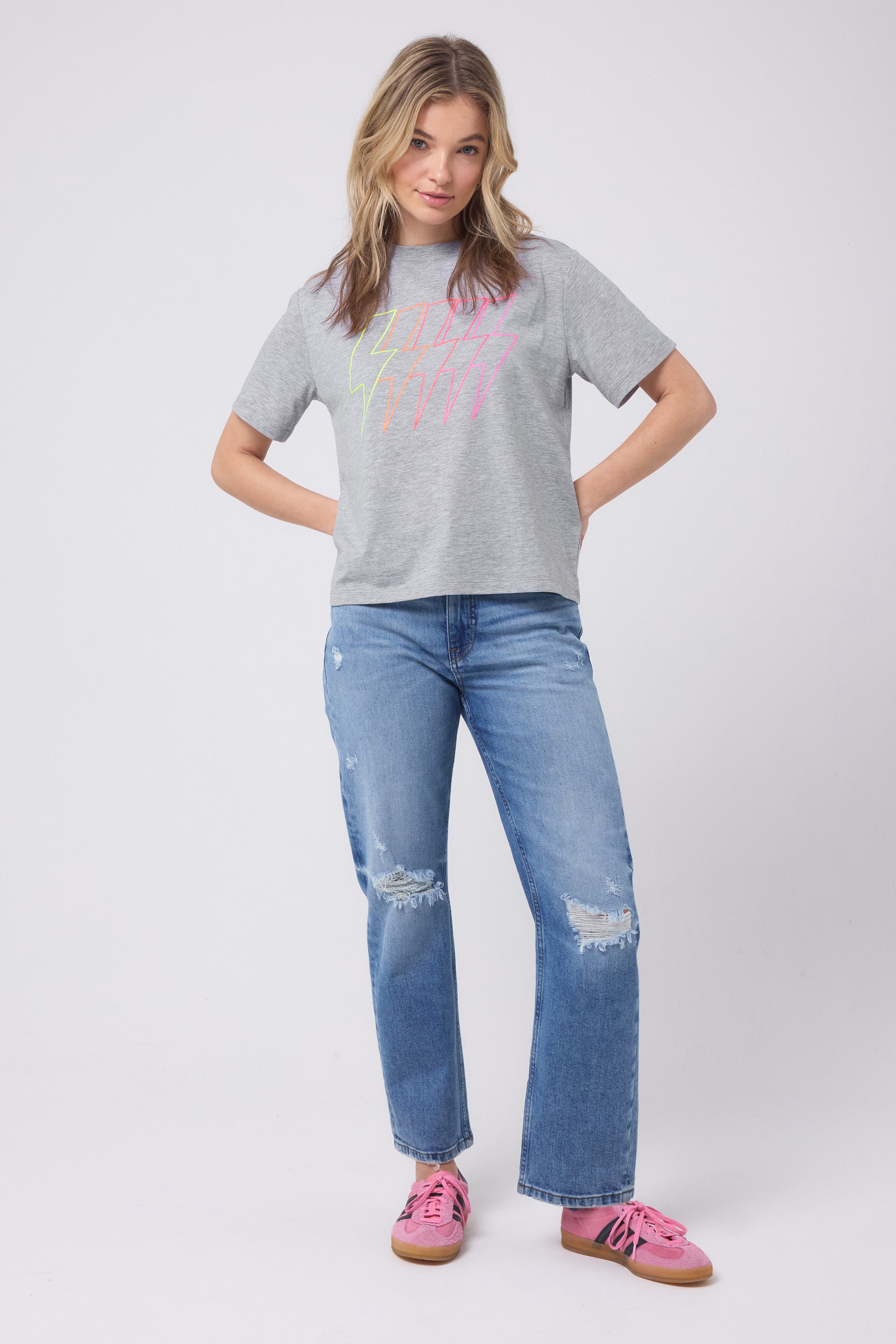 Scamp and Dude Grey Marl Multi Bolt Classic T-Shirt | Model wearing a short sleeve grey t-shirt with neon bolt detail and distressed blue denim jeans.