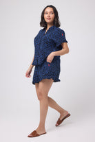 Scamp and Dude Navy with Black Rock and Roll Leopard Frill Hem Shorts | Model wearing dark navy leopard print shirt and shorts co-ord with brown flat sandals.