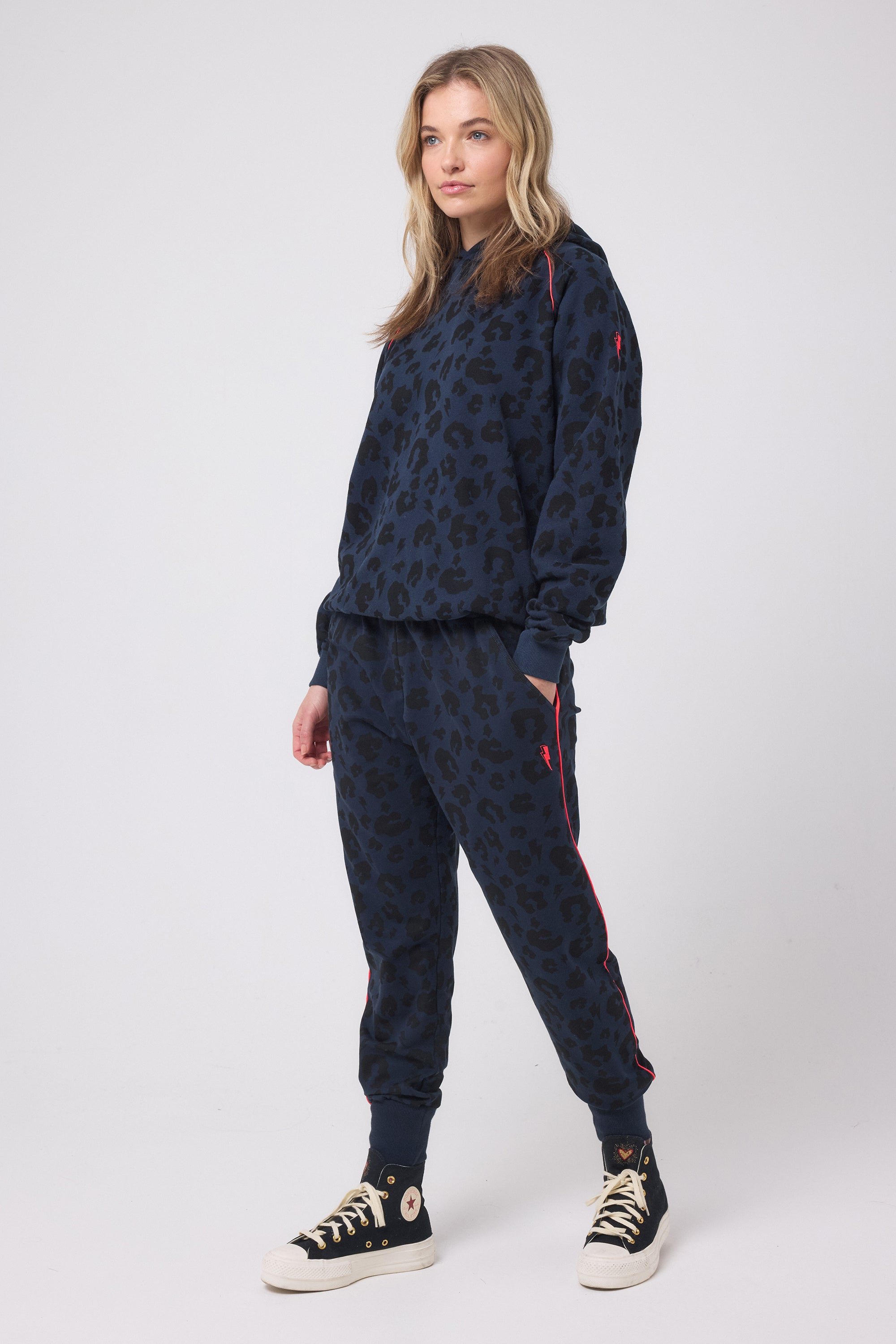 Scamp and Dude Navy Leopard Cosy Joggers | Model wearing dark navy jumper with leopard print, paired with matching joggers and black trainers.