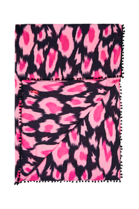 A folded black with hot pink and pink leopard ikat and lightning bolt print scarf with a black pom pom trim