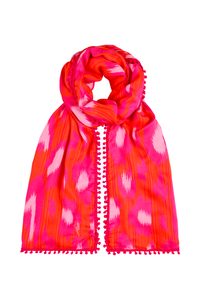 A red with hot pink and pale pink leopard ikat and lightning bolt print scarf with a pink pom pom trim 