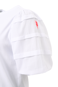 A close-up of a white T-shirt with pintuck detailing on the sleeve and a neon pink embroidered lightning bolt