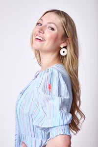 A blonde lady wearing a pale blue tie front maxi dress with rainbow lurex stripes and 3/4 blouson sleeves