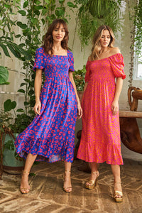 Two women wearing Scamp and Dude midi dresses with blouson sleeves in different patterns and colours