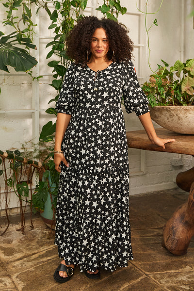 Scamp and Dude Black and White Star Print Maxi Dress | Model wearing a black and white star print with plants in background