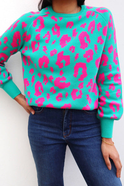 Scamp and Dude Green and Pink Leopard Print Sweatshirt | Model wearing green and pink leopard print jumper with blue jeans